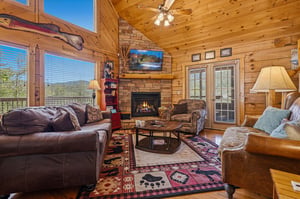Sink into soft leather and plush seating around the stone fireplace, where warmth and mountain charm create your perfect retreat.
