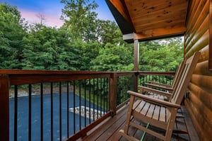 Cozy wooden deck framing a tranquil river flowing through lush forest—perfect for your morning coffee or evening relaxation with natures soundtrack all around.
