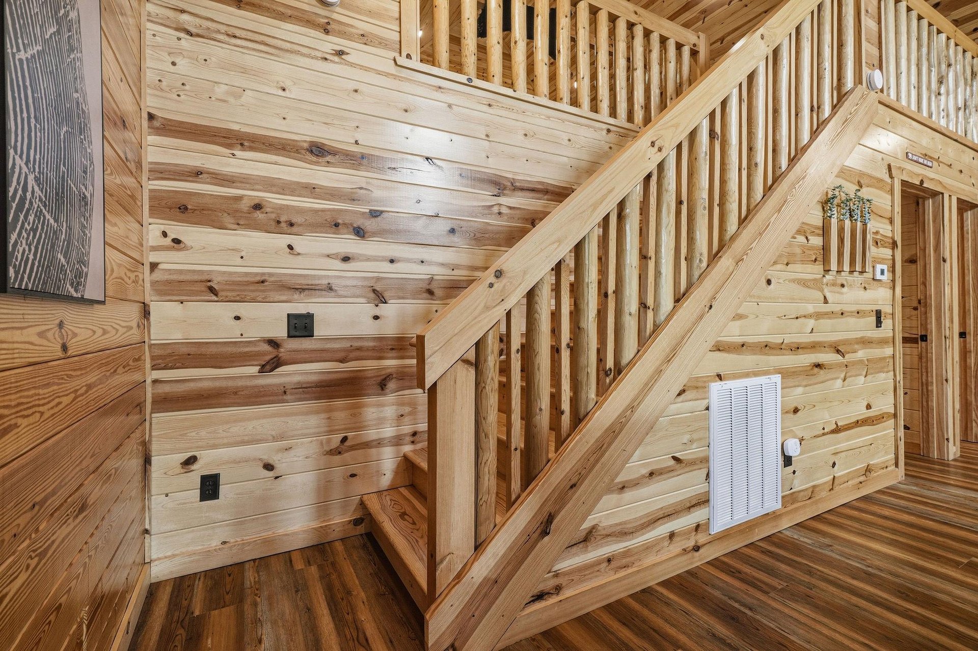 Enjoy the warmth and character of this allwood interior, where natural grain and rustic craftsmanship surround you. A cozy staircase invites you upstairs, blending function with charm throughout your