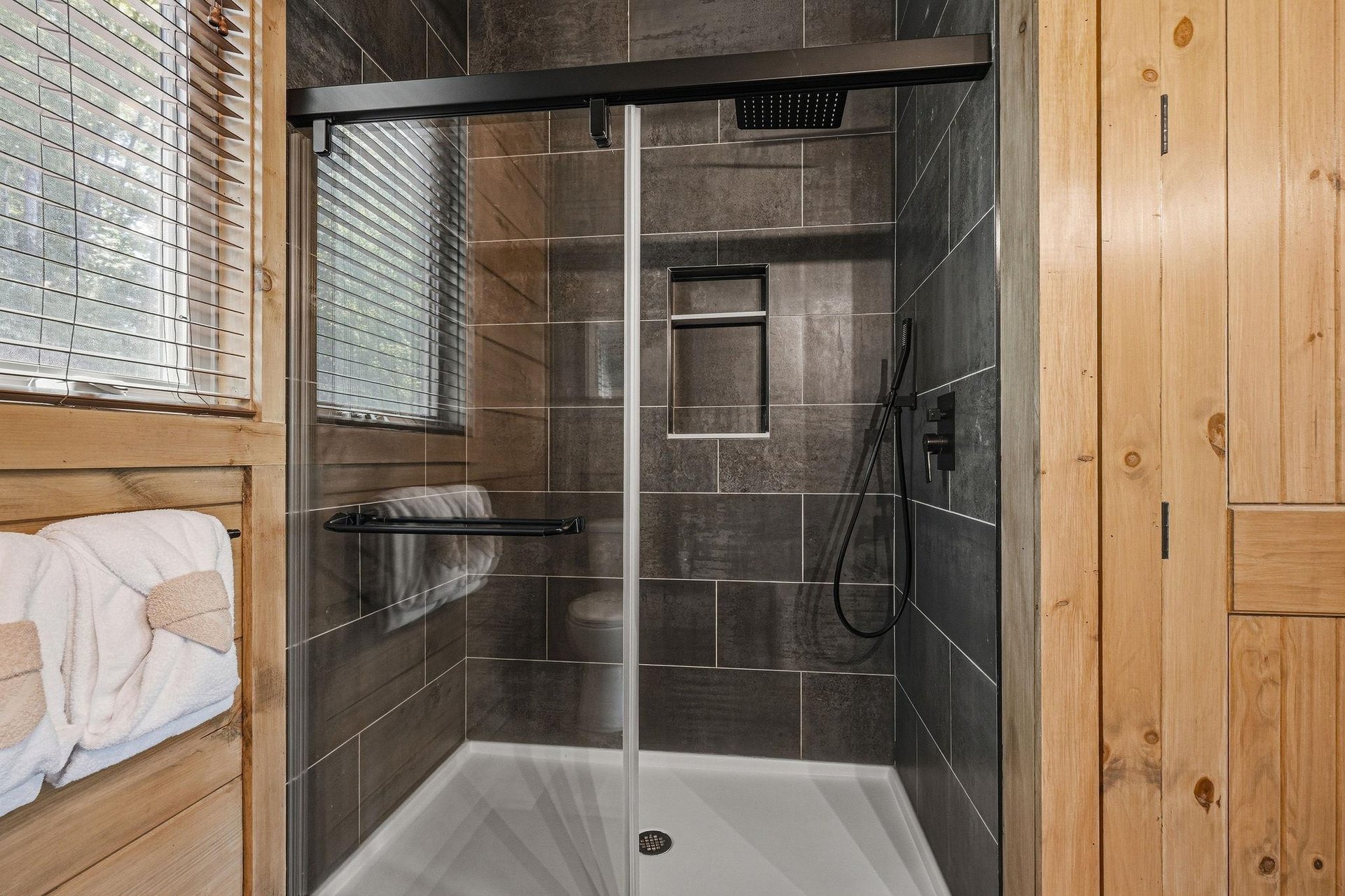 Step into your sleek, modern shower with rainfall head and glass enclosure—fresh towels await your relaxing retreat.