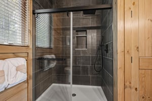 Step into your sleek, modern shower with rainfall head and glass enclosure—fresh towels await your relaxing retreat.