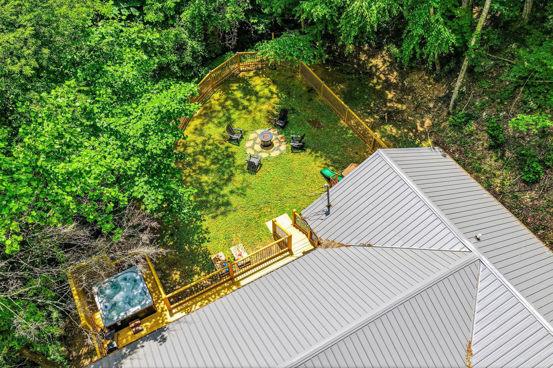 A secluded vacation rental nestled in lush woodland, featuring a private fenced yard with fire pit, deck with hot tub, and peaceful natural surroundings for ultimate relaxation.