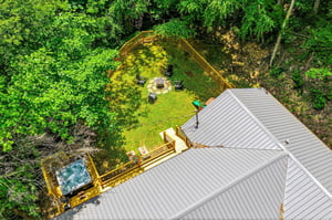 A secluded vacation rental nestled in lush woodland, featuring a private fenced yard with fire pit, deck with hot tub, and peaceful natural surroundings for ultimate relaxation.