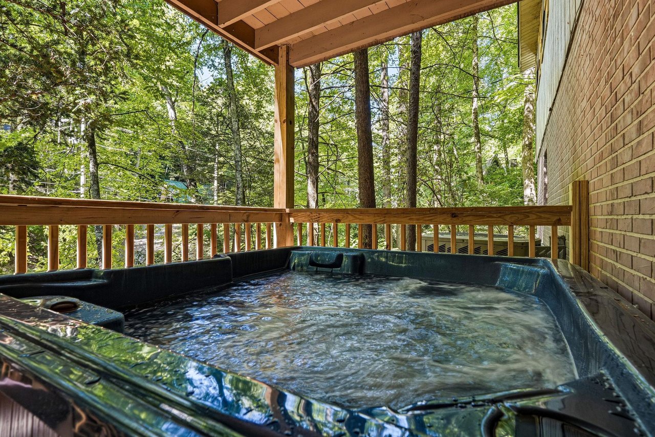 Unwind in your private covered hot tub, where soothing jets and a serene forest backdrop create your perfect woodland escape.