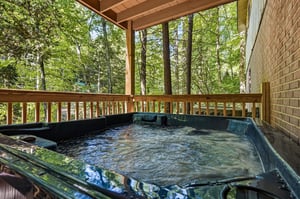 Unwind in your private covered hot tub, where soothing jets and a serene forest backdrop create your perfect woodland escape.