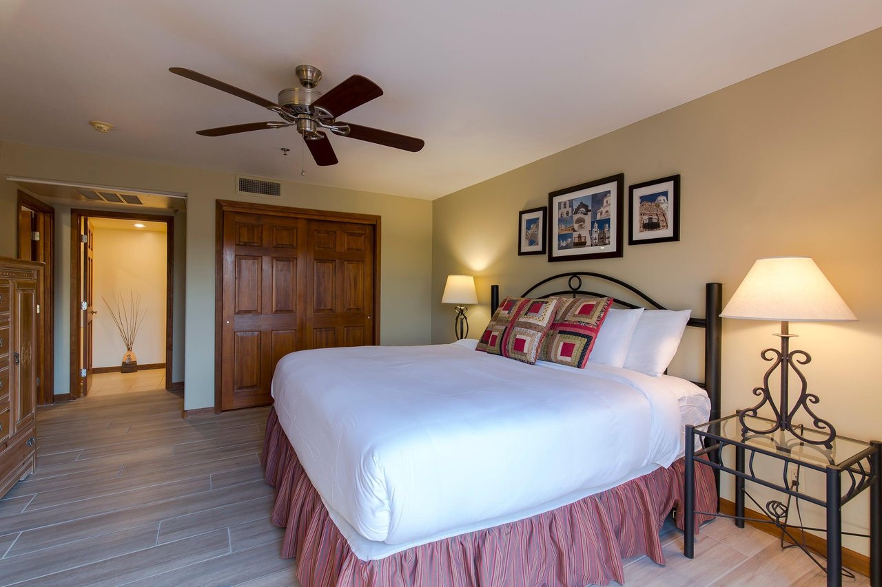 King size bed, desk, ceiling fan, and direct patio access.