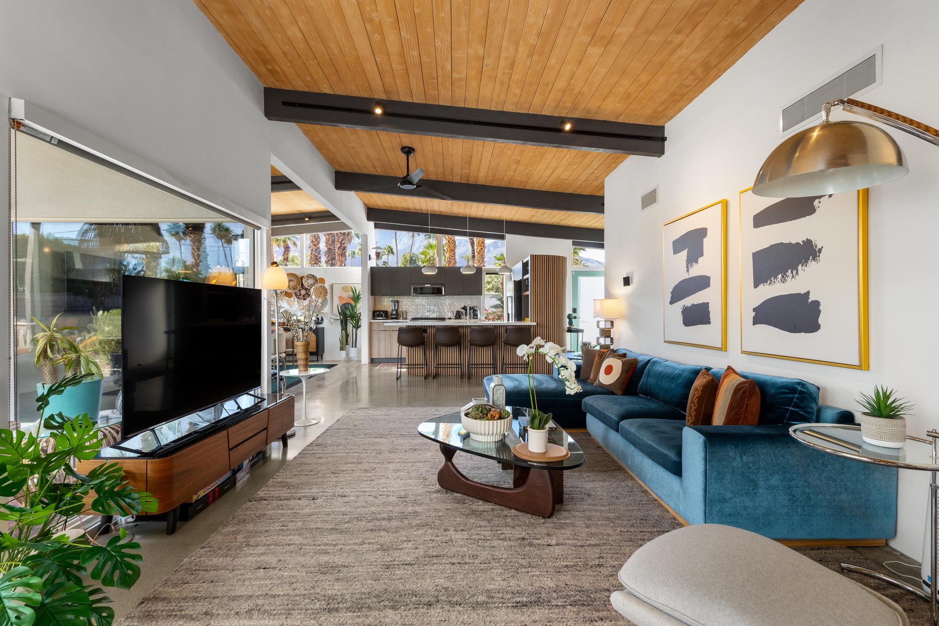 Relax in your stylish midcentury living room with soaring wood ceilings, designer furnishings, and seamless indooroutdoor flow.