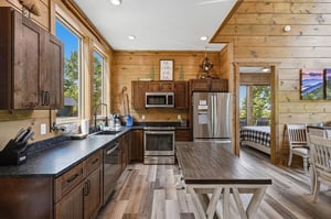 Gather around this beautiful rustic kitchen featuring modern appliances, rich wood accents, and warm mountain cabin charm.