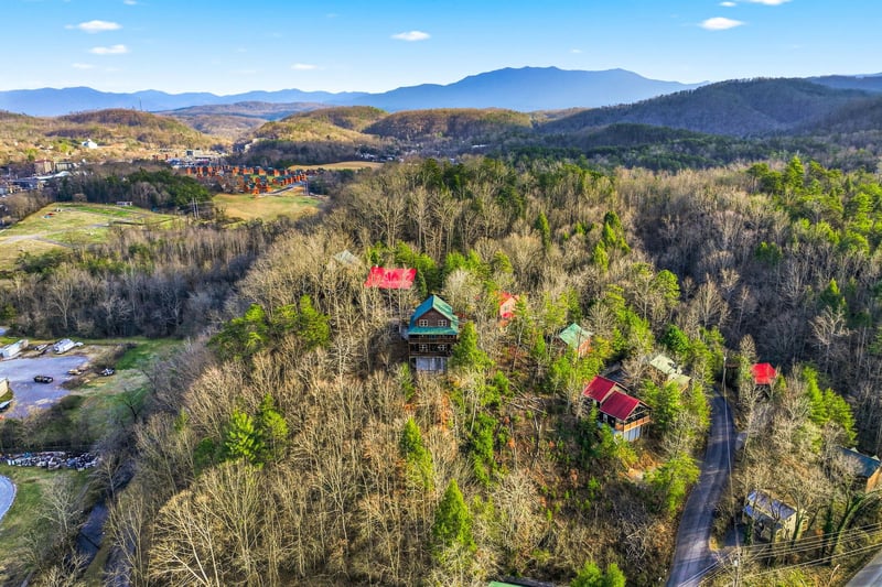 Aerial view showcasing mountain cabins nestled among rolling hills and forested valleys in the scenic Appalachian region.