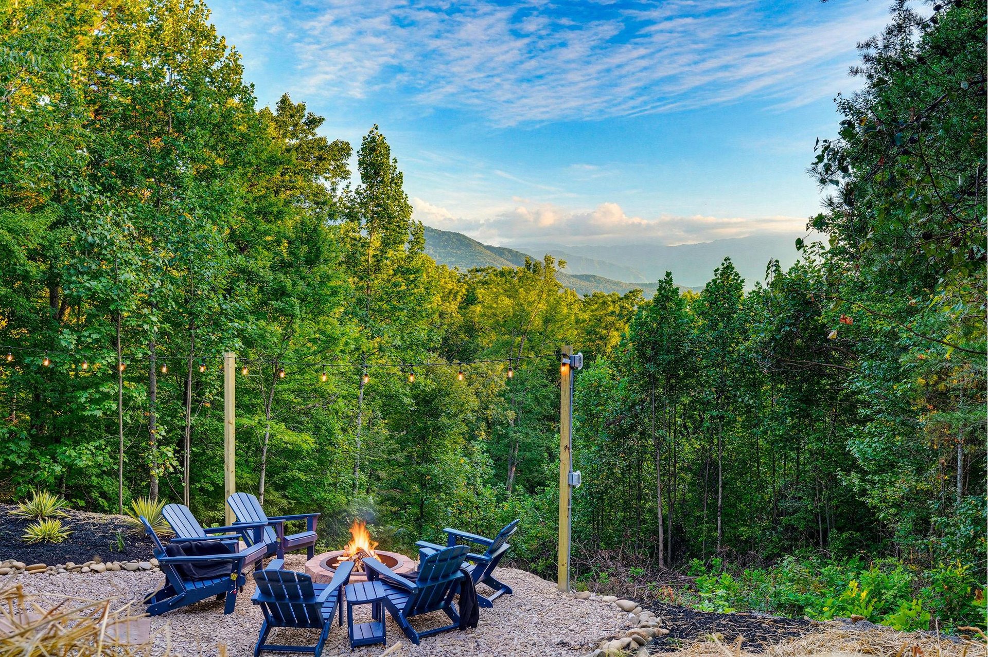 A fire pit on the property surrounded by Adirondack chairs, set against a natural mountain backdrop—an ideal spot for outdoor relaxation.