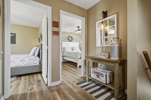 Step into your cozy hallway, where rustic charm meets comfort. Warm wood floors guide you to inviting bedrooms, each styled for restful nights. A charming console with farmhouse touches welcomes you h