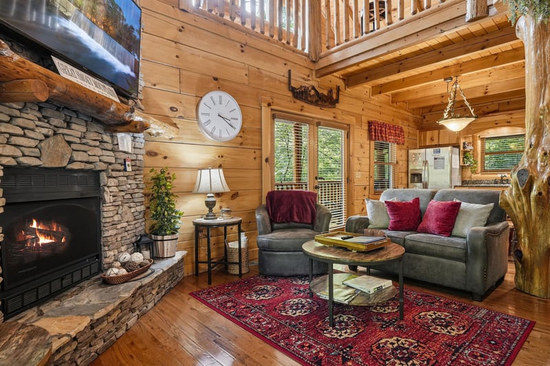 Settle into your cozy cabin retreat with warm wood beams, a crackling stone fireplace, and plush seating where you can unwind after a day of mountain adventures.