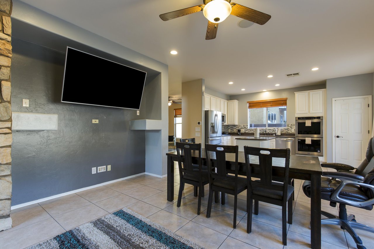 Dining table, chairs, and  flatscreen TV that is also viewable from the living room.