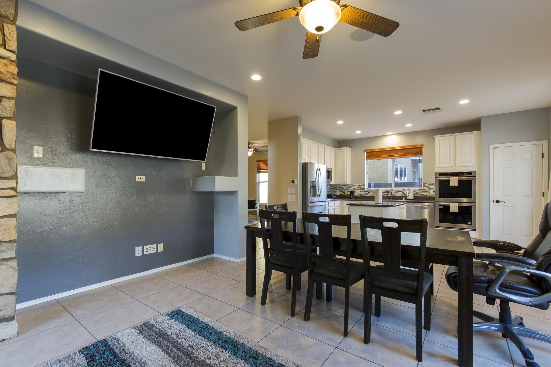 Dining table, chairs, and  flatscreen TV that is also viewable from the living room.