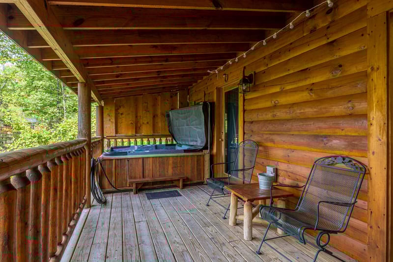 Covered deck with hot tub and seating at Dukes Den