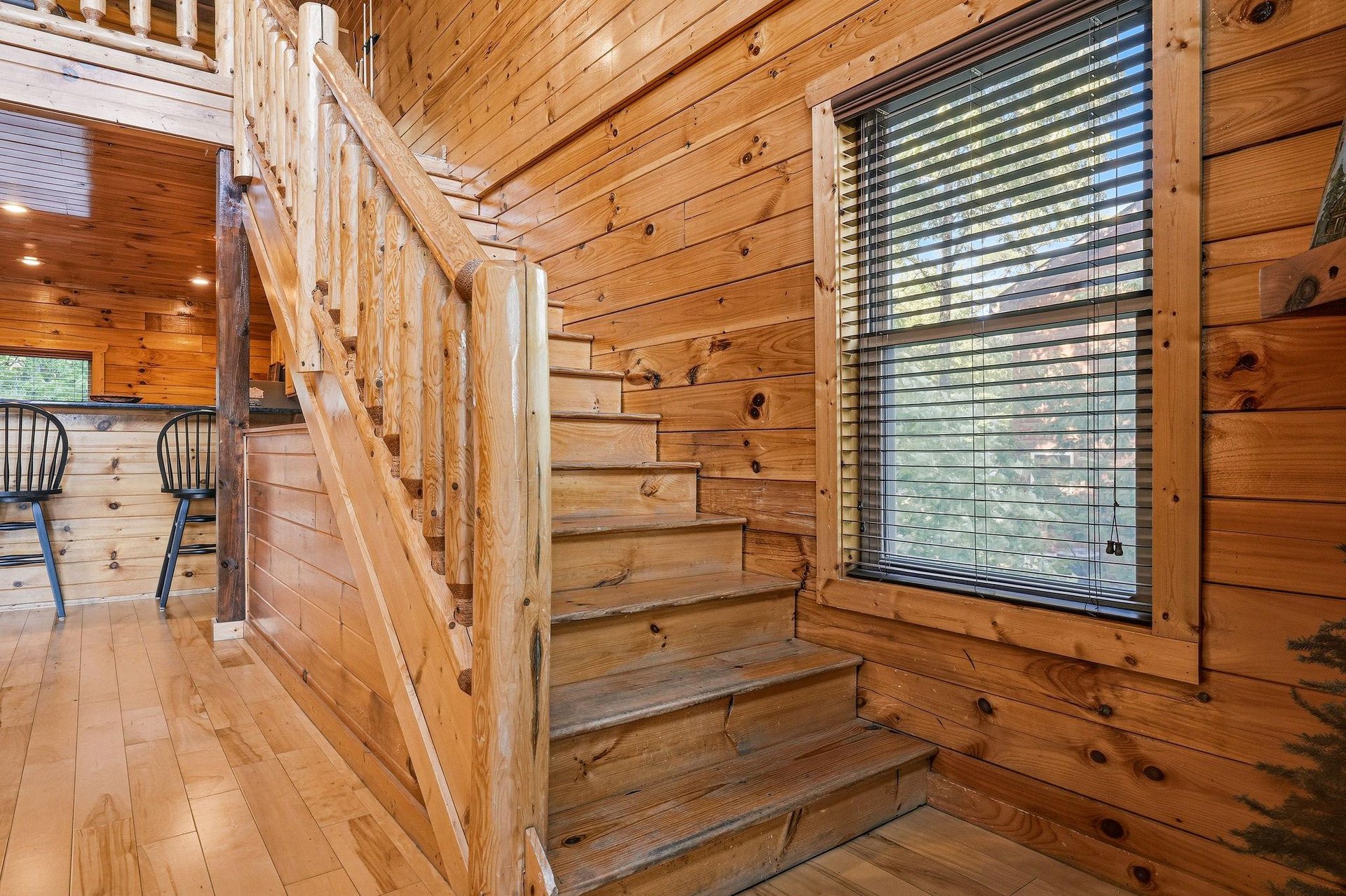 Warm wood tones welcome you throughout this cabinstyle retreat, where natural light streams through large windows and a wooden staircase leads to your private loft above.