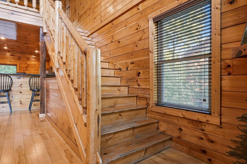 Warm wood tones welcome you throughout this cabinstyle retreat, where natural light streams through large windows and a wooden staircase leads to your private loft above.