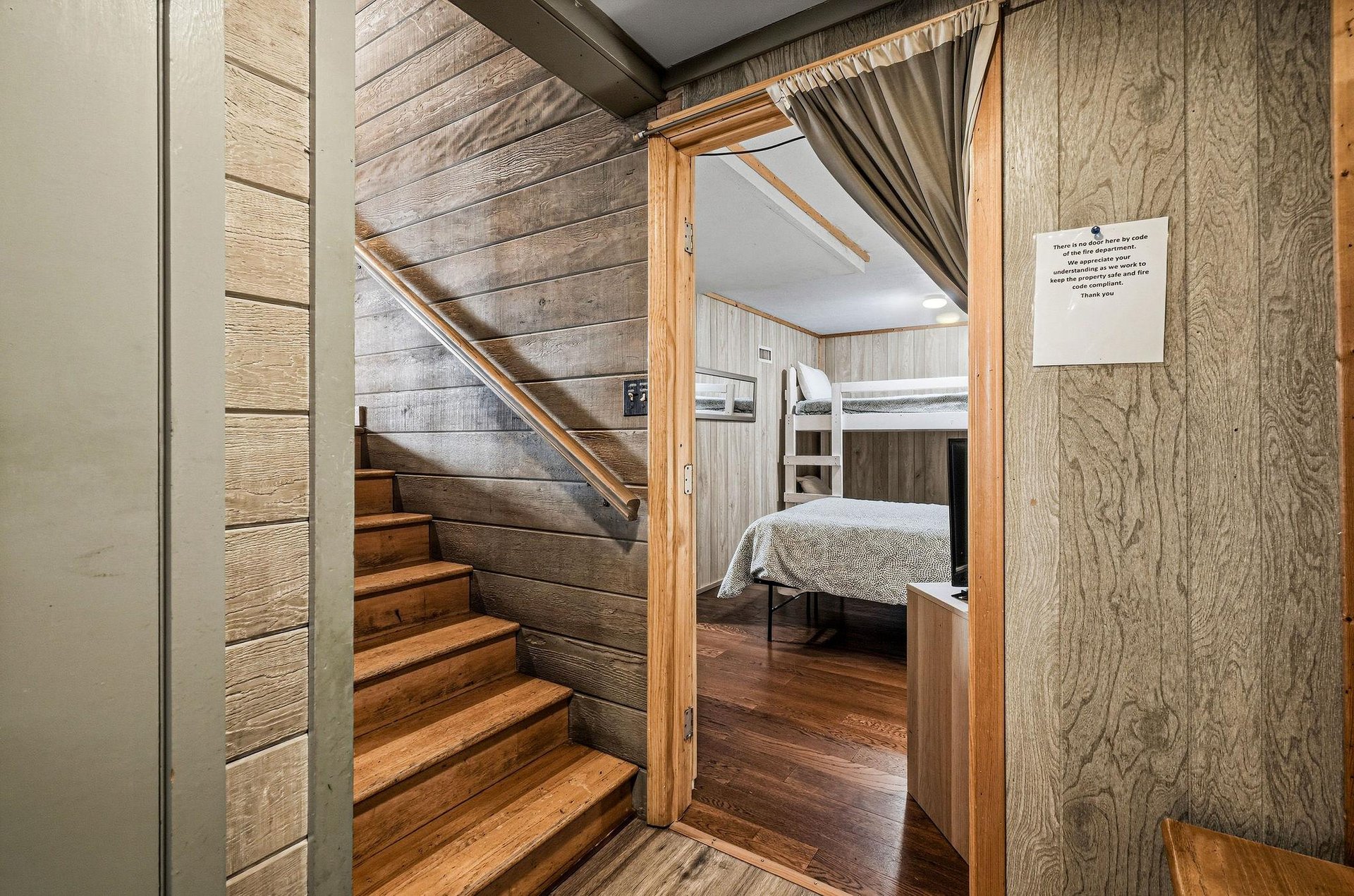 Step into your cozy retreat where rustic wood walls and gleaming floors create the perfect mountain cabin atmosphere for restful nights.