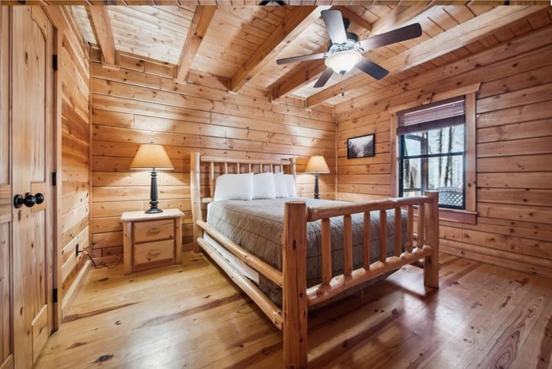 Drift off to sleep surrounded by warm wood walls and rustic charm in your cozy cabin bedroom retreat.