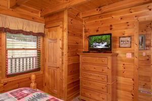 Bedroom with a television and dresser at Hibernation Station, a 3bedroom cabin rental located in Pigeon Forge