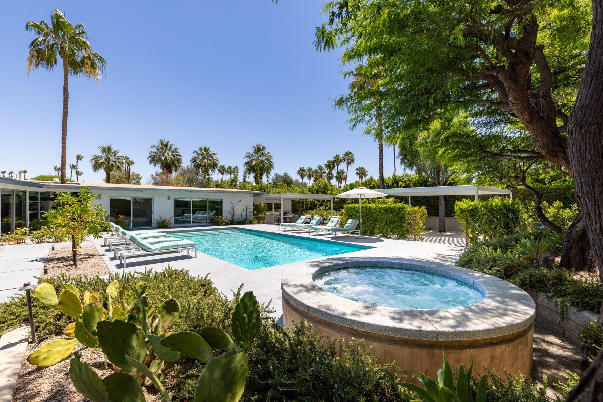 Private poolspa with sun loungers and umbrellas.