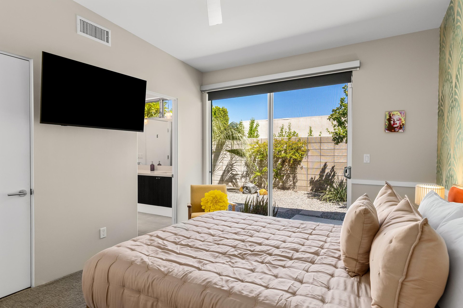Queen size bed, plenty of natural lighting, access to the outdoor space, and shared jackandjill bathroom.