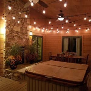 Unwind under twinkling string lights in your private covered patio, where a bubbling hot tub and stone fireplace invite relaxation after exploring.