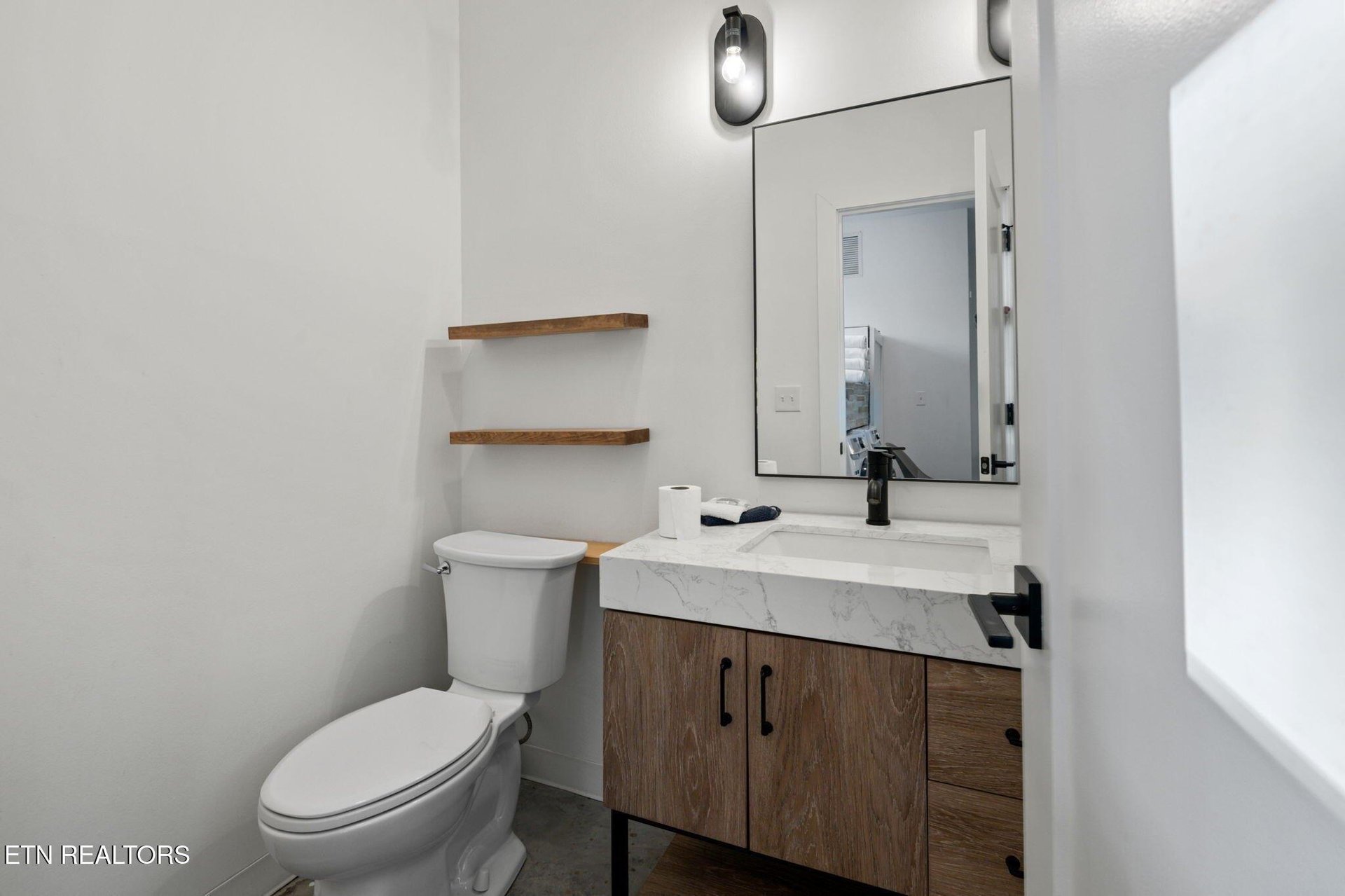 Step into your sleek, modern bathroom with clean lines and warm wood accents. The bright marble countertop and contemporary fixtures create a fresh, inviting space for your morning routine.