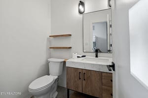 Step into your sleek, modern bathroom with clean lines and warm wood accents. The bright marble countertop and contemporary fixtures create a fresh, inviting space for your morning routine.