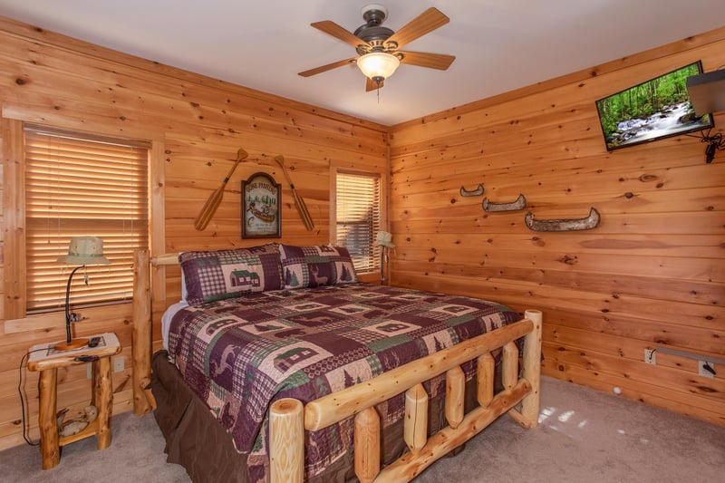 Bedroom with a kingsized log bed and TV at Great View Lodge, a 5bedroom cabin rental located in Pigeon Forge