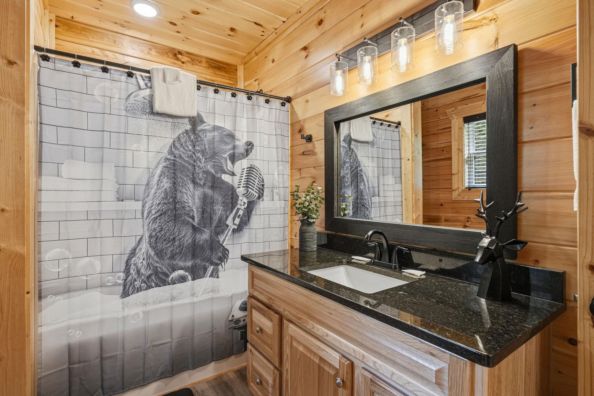 Enjoy your personal bathroom featuring a full tub with shower, granite vanity, and charming wood walls. Whimsical touches await throughout your mountain escape.