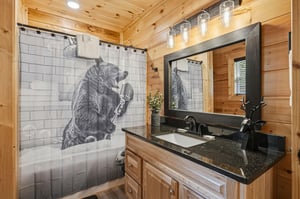 Enjoy your personal bathroom featuring a full tub with shower, granite vanity, and charming wood walls. Whimsical touches await throughout your mountain escape.