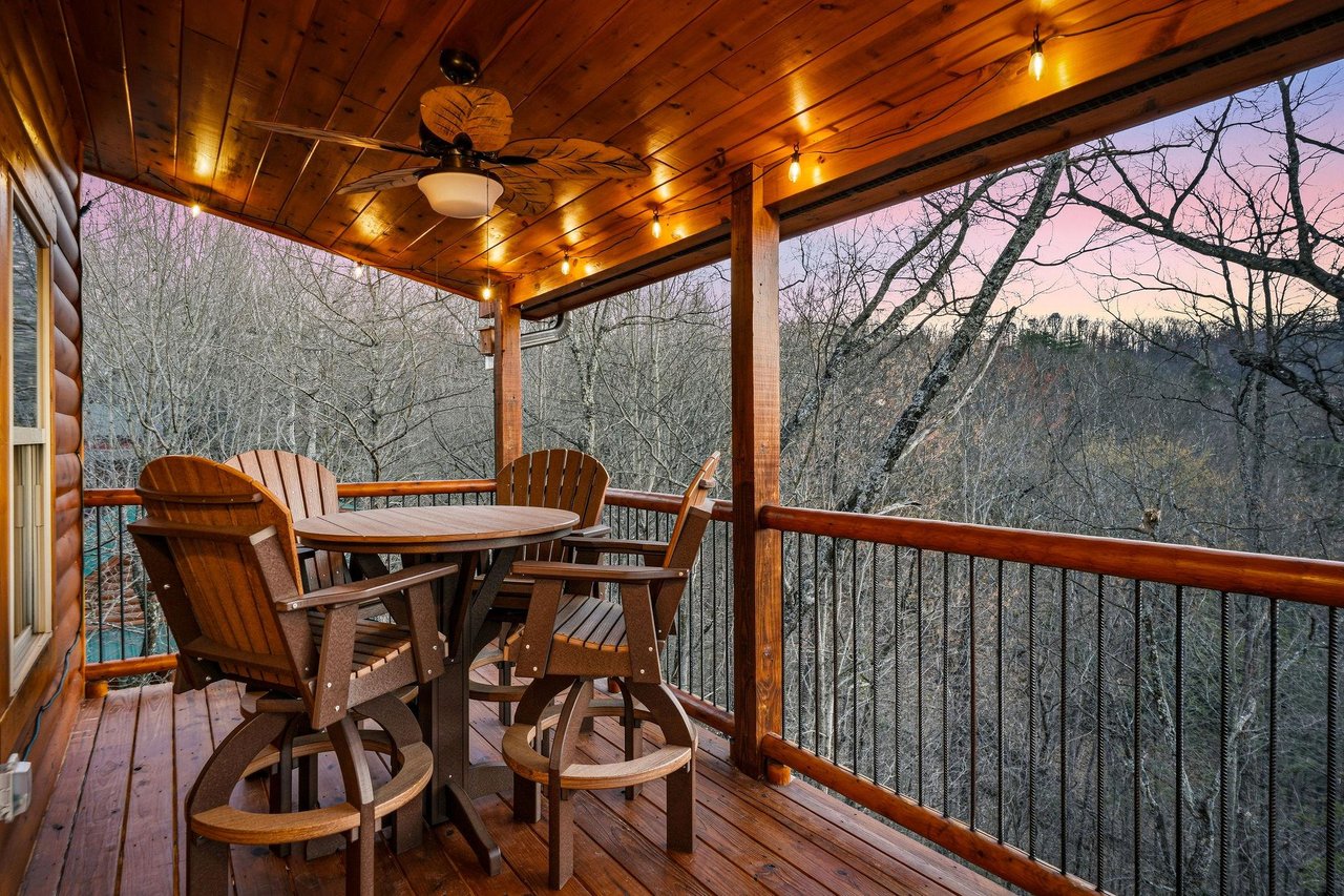 Enjoy your morning coffee on this covered deck with mountain views and twinkling lights creating the perfect ambiance.
