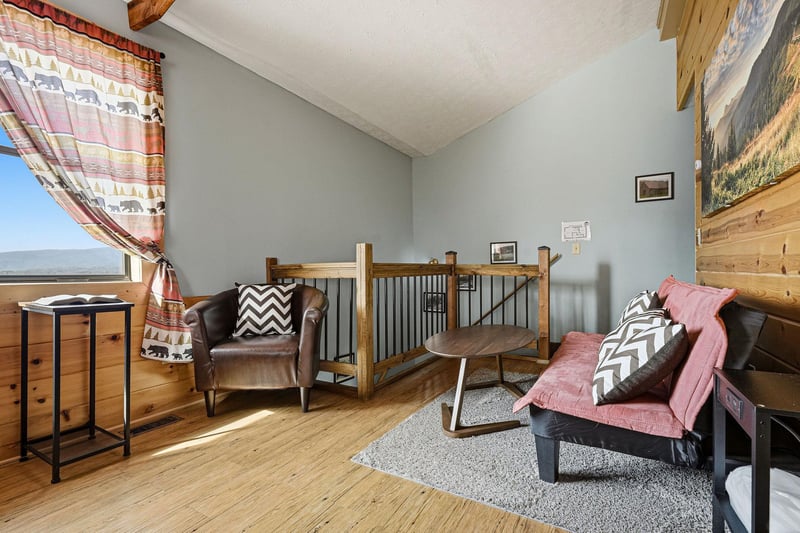 Curl up in your cozy living space with rustic wood accents, comfortable seating, and beautiful mountain views through oversized windows.