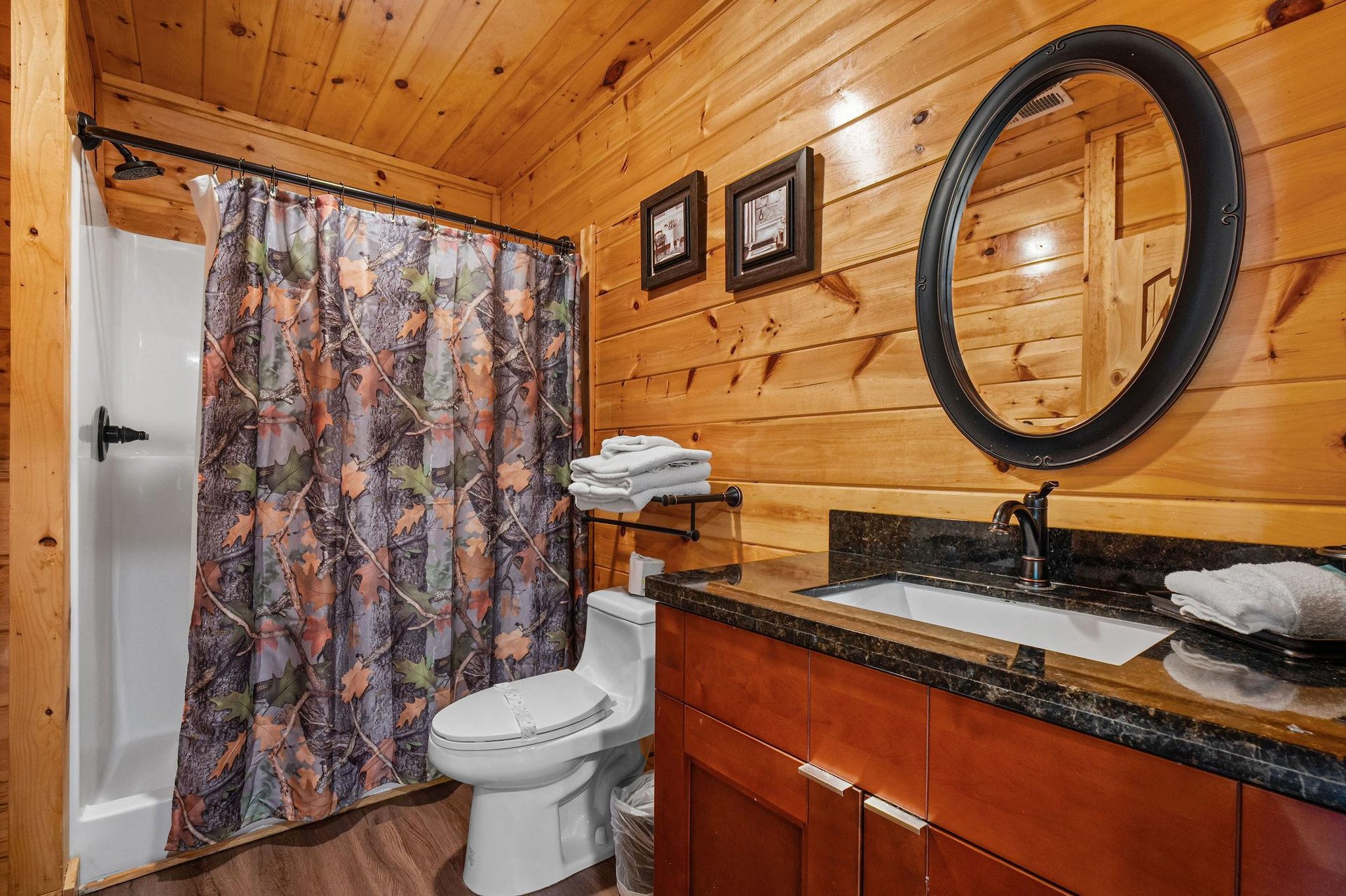 Full bathroom with single vanity and round mirror