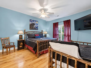 Unwind in your cozy bedroom with rustic wood furnishings, gentle ceiling fan, and room for the whole family—featuring both a queen bed and a twinoverfull bunk bed for extra comfort.