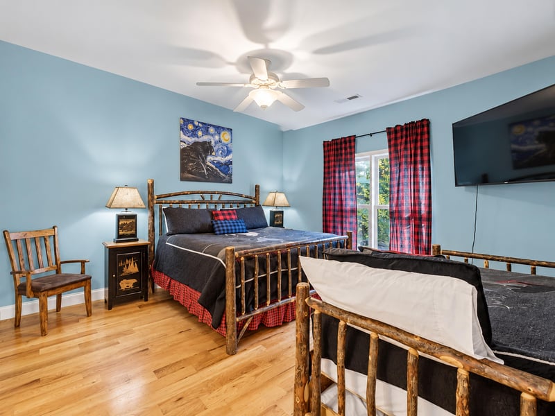 Unwind in your cozy bedroom with rustic wood furnishings, gentle ceiling fan, and room for the whole family—featuring both a queen bed and a twinoverfull bunk bed for extra comfort.