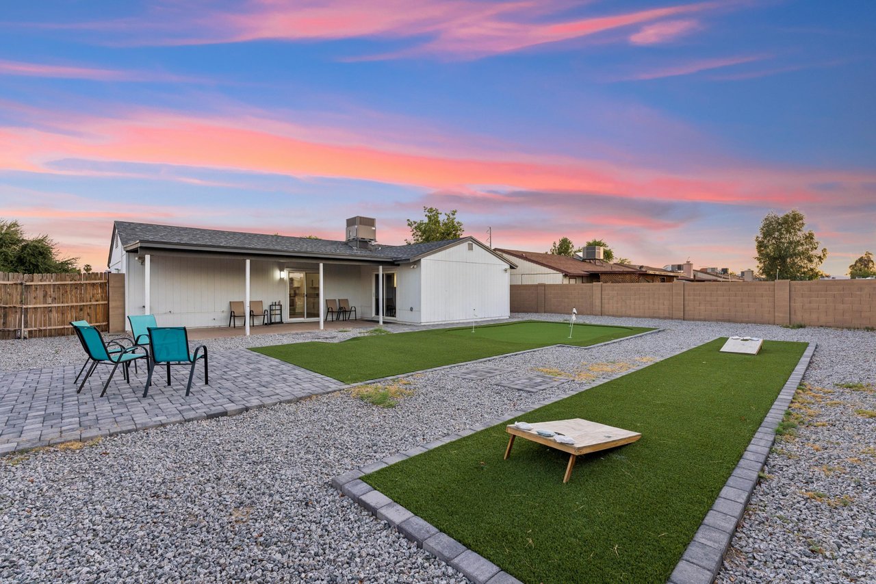 Beautiful outdoor space with a patio, outdoor seating, corn hole, and putting green.