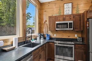 Your fully equipped cabin kitchen blends rustic charm with modern conveniences, featuring granite counters and lake views to inspire homecooked meals.