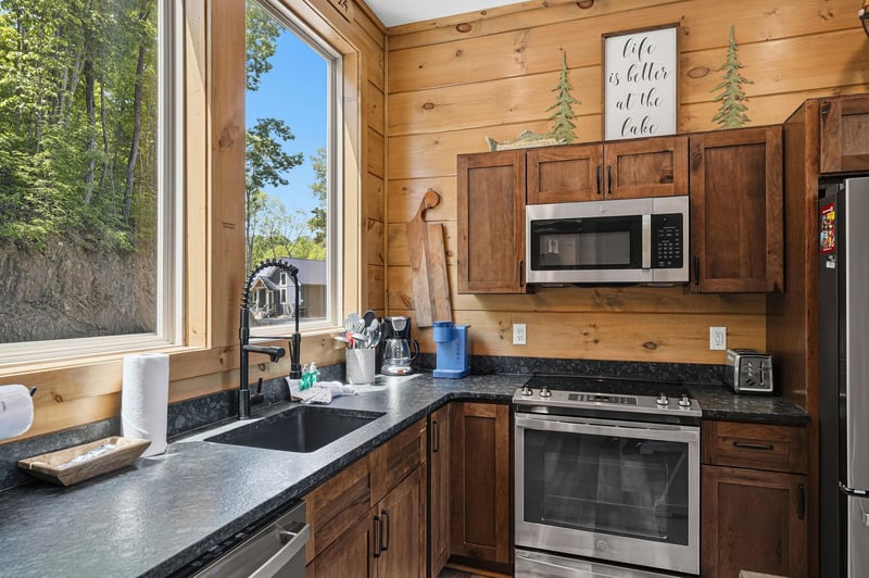 Your fully equipped cabin kitchen blends rustic charm with modern conveniences, featuring granite counters and lake views to inspire homecooked meals.