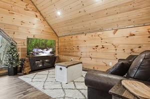 Unwind in your cozy log cabin living room where warm wood surrounds you and a large TV awaits your favorite shows.