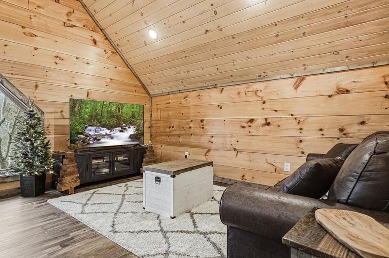 Unwind in your cozy log cabin living room where warm wood surrounds you and a large TV awaits your favorite shows.