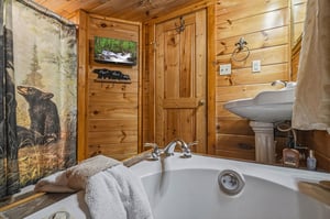 Sink into the deep soaking tub surrounded by warm wood walls, where naturethemed touches and cozy towels await your relaxation.