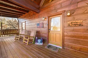 Covered deck seating at Livin Simple, a 2 bedroom cabin rental located in Pigeon Forge
