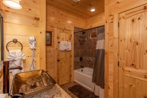 Single vanity sink and bathtub with tile wall