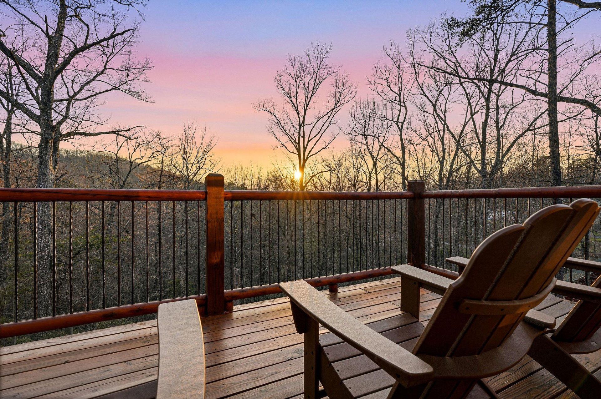 Stunning sunrise view from the deck overlooking bare winter trees and rolling landscape.