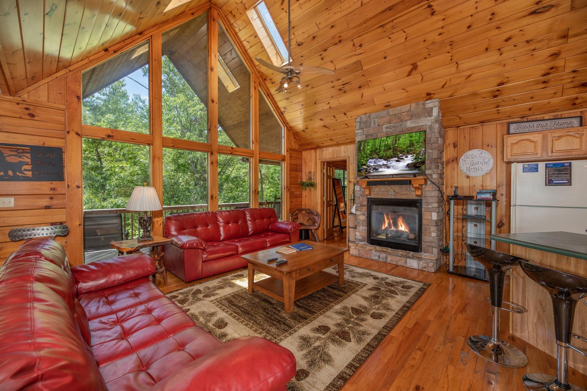 Main room with sofas, fireplace, TV, and kitchen at Hello Dolly, a 1 bedroom cabin rental located in Pigeon Forge