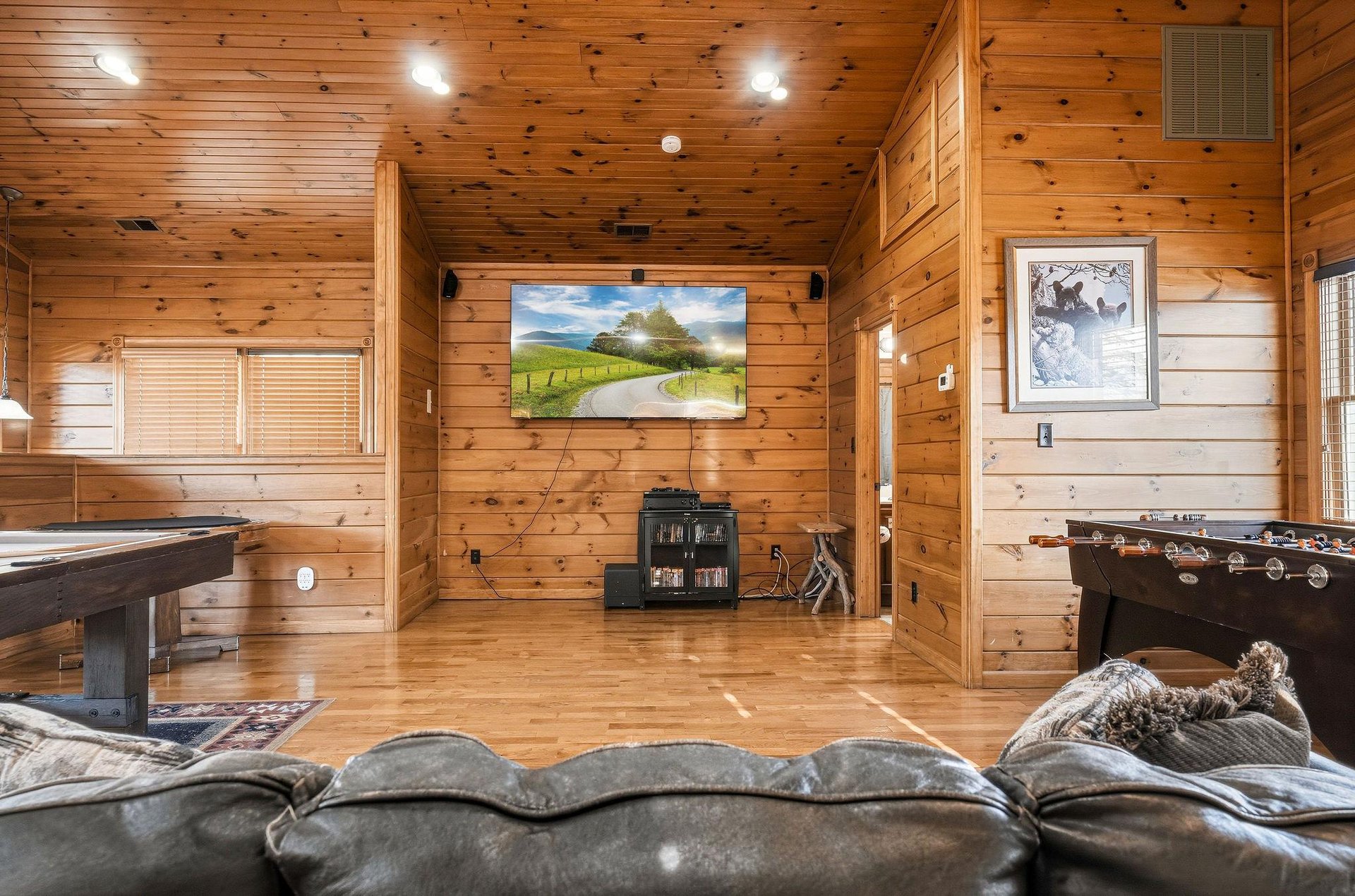 Settle into your private game room with warm knotty pine walls, a bigscreen TV for movie nights, air hockey, and foosball—your perfect space to unwind and compete.
