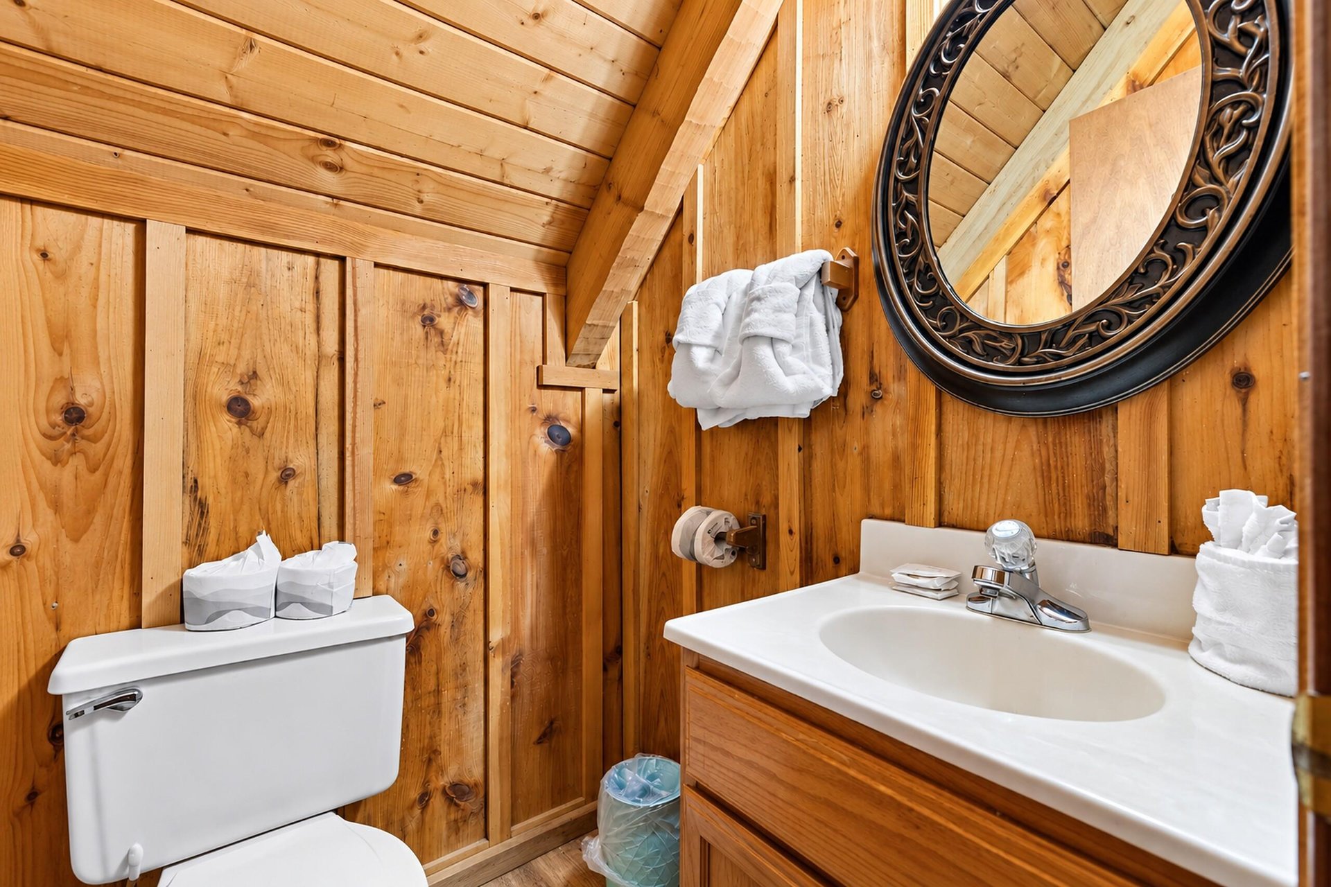 Rustic charm meets convenience in this wellappointed bathroom with warm wood paneling and fresh linens ready for your stay.