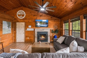 Relax in your cozy living room with vaulted wood ceilings, a warm fireplace, and plush seating that invites you to unwind after a day of adventure.